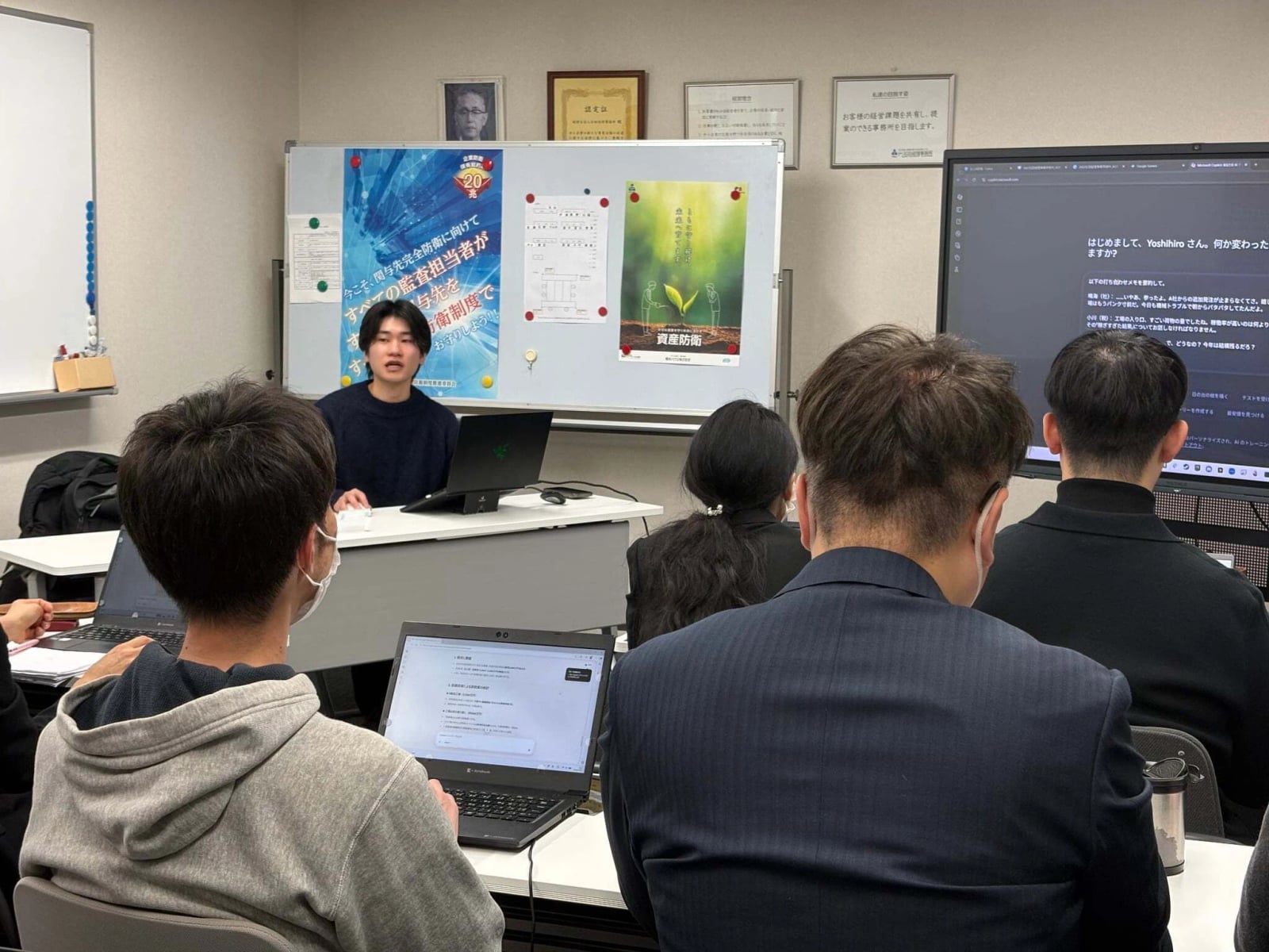 石田経理事務所での生成AI活用研修の様子。会議室にノートPCを開いた職員が並び、講師がスクリーンの前で説明している