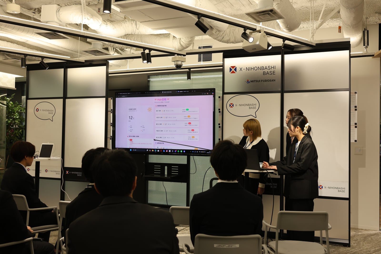 長岡高専チームによる Hair日和 の発表。スクリーンに UI モックアップが投影されている